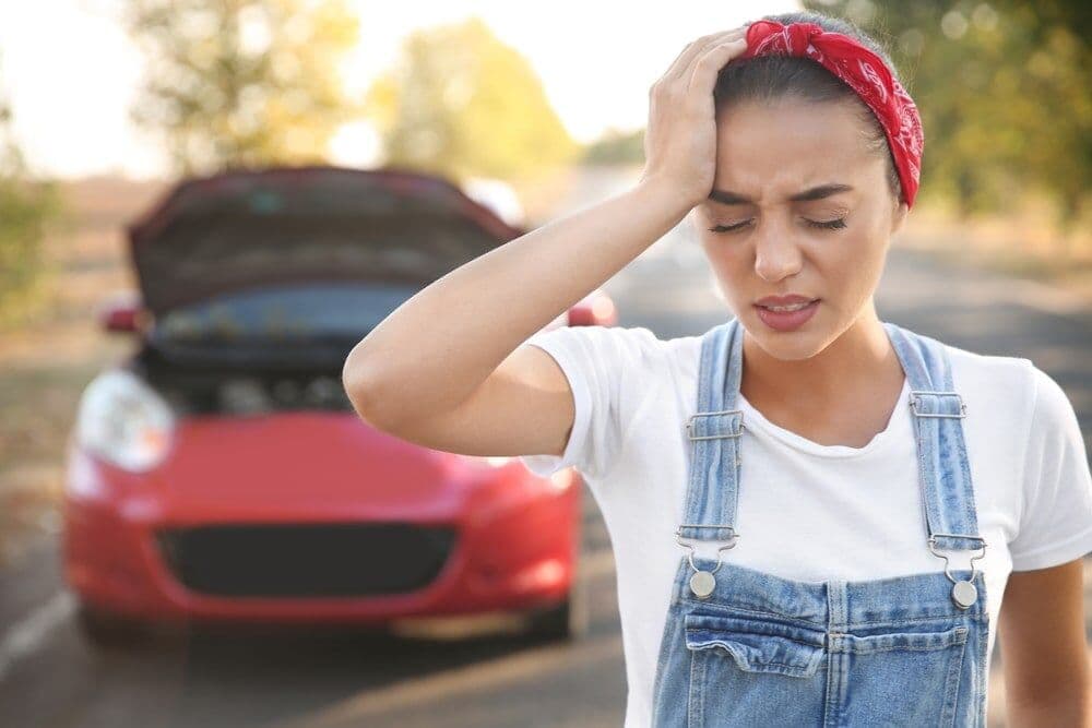 Woman holding her head in pain after a car accident — cervicogenic headache and whiplash, Forest Hills Queens NY
